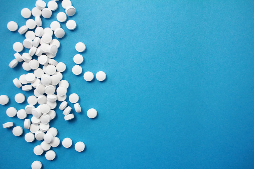 white pills blue background