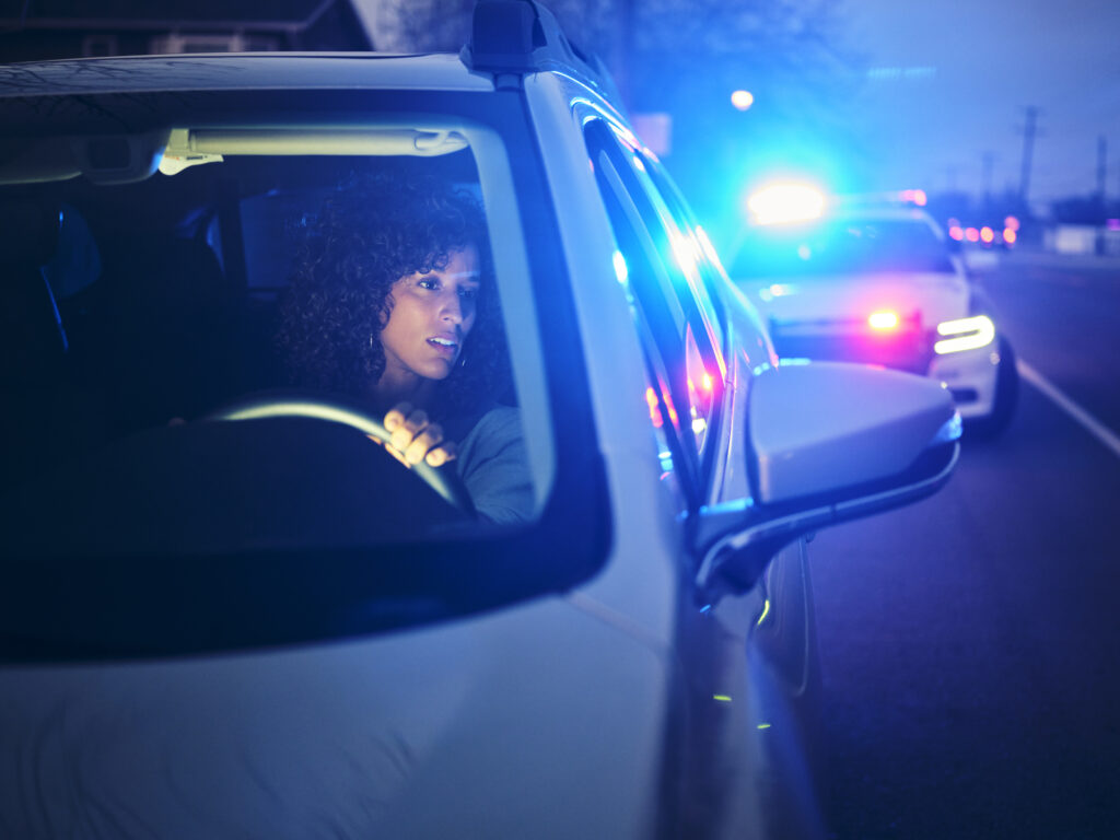 young woman pulled over by police car