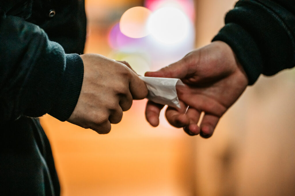 man handing bag of cocaine to another man