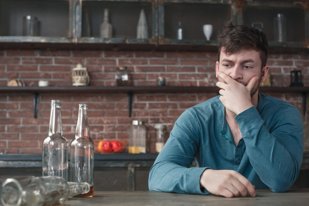 young man alcoholic sitting drunk