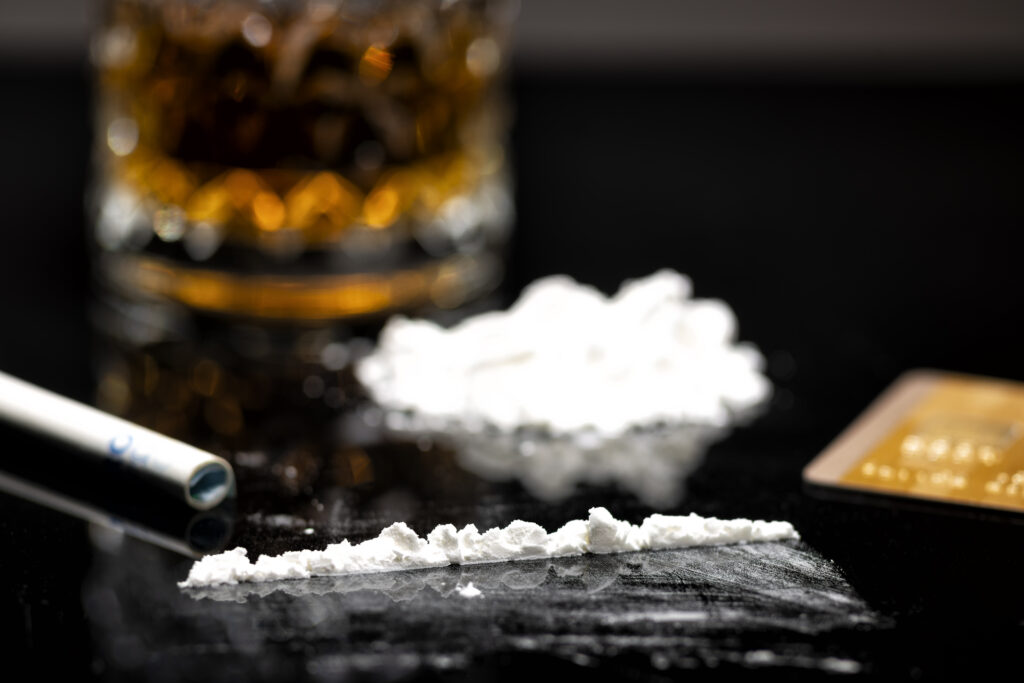 line of crack cocaine with glass of whiskey