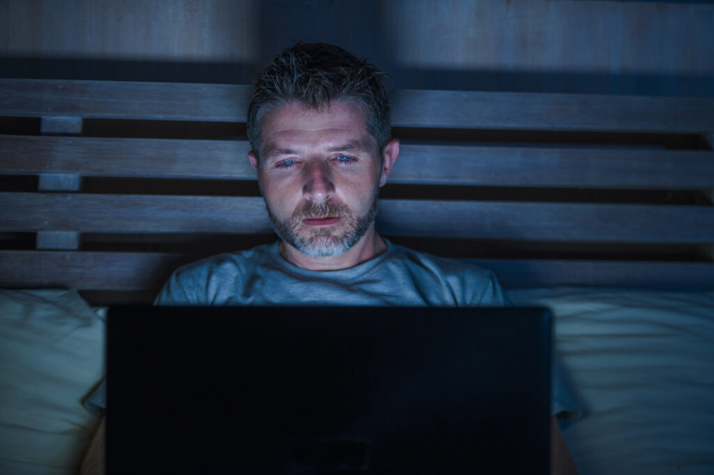porn addict in bed with laptop