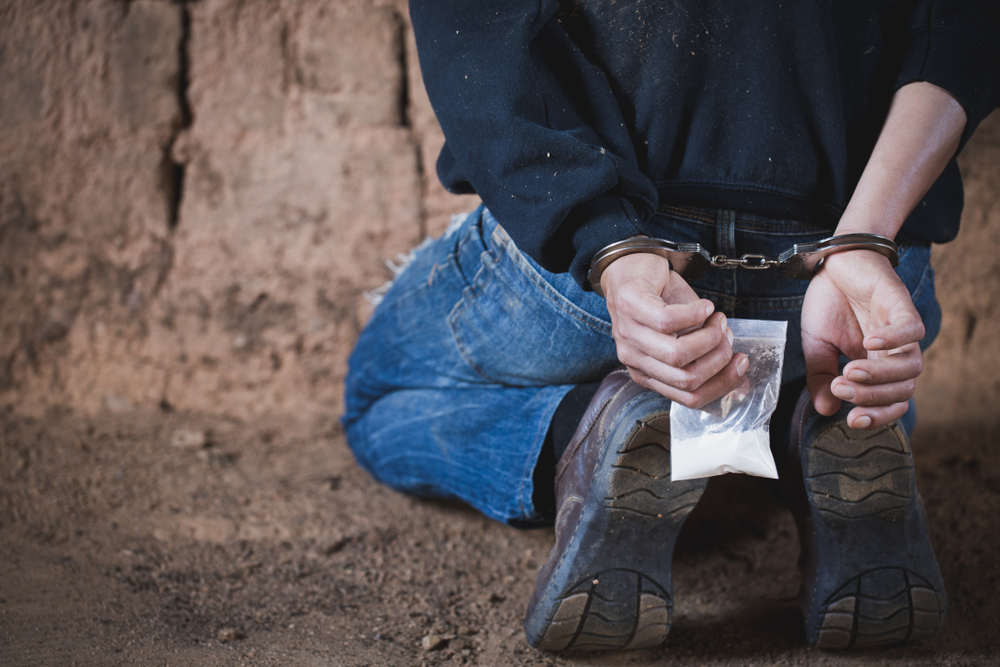 man handcuffed arrested with bag of cocaine