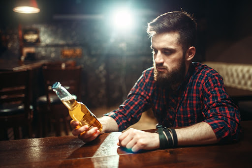 man-holding-beer-at-bar